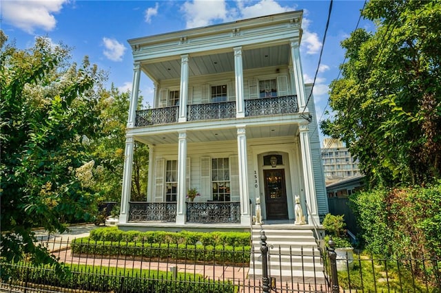 view of front facade with covered porch and a balcony