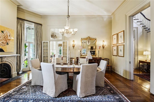 dining room with french doors, a high end fireplace, a notable chandelier, ornamental molding, and dark wood-type flooring