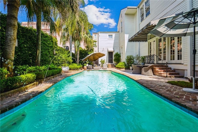 view of swimming pool with a patio area and french doors