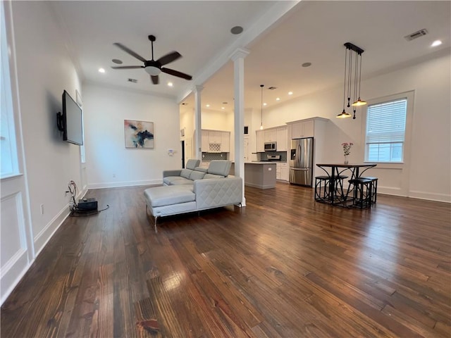 living room featuring ornate columns, dark hardwood / wood-style floors, and ceiling fan