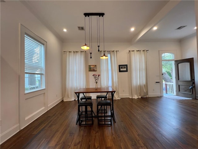 dining area with crown molding and dark wood-type flooring