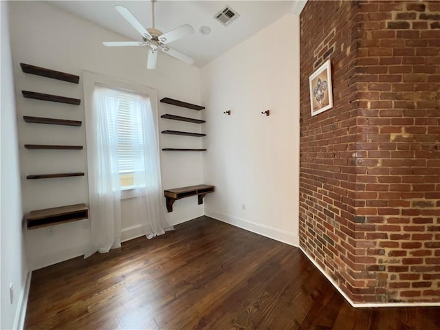 unfurnished bedroom with brick wall, vaulted ceiling, and dark hardwood / wood-style flooring