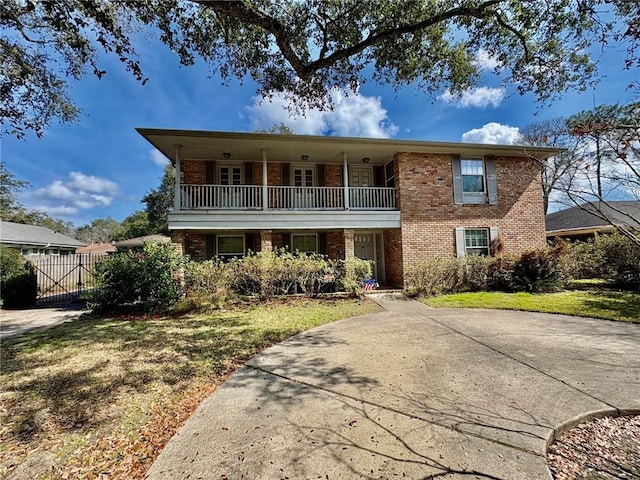 view of property with a front lawn and a balcony