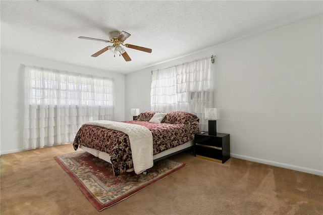 carpeted bedroom with ceiling fan and a textured ceiling