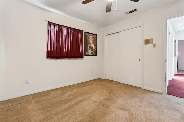 unfurnished bedroom with ceiling fan, a closet, and light colored carpet