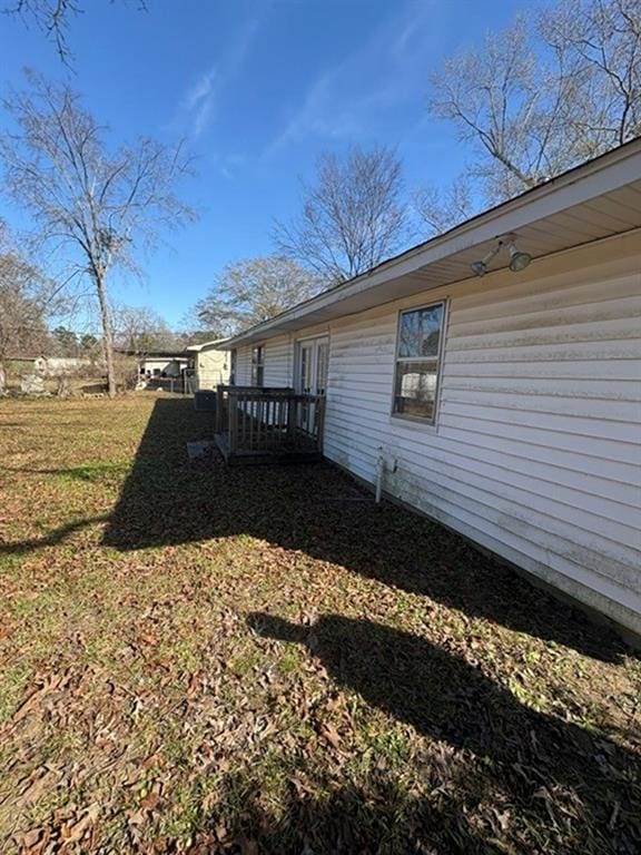 view of property exterior featuring a deck and a lawn