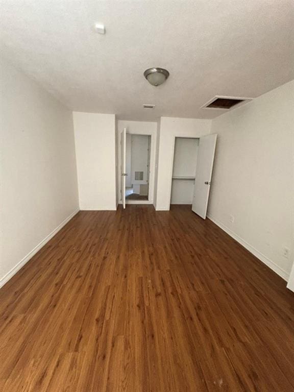 unfurnished bedroom featuring a closet and dark wood-type flooring