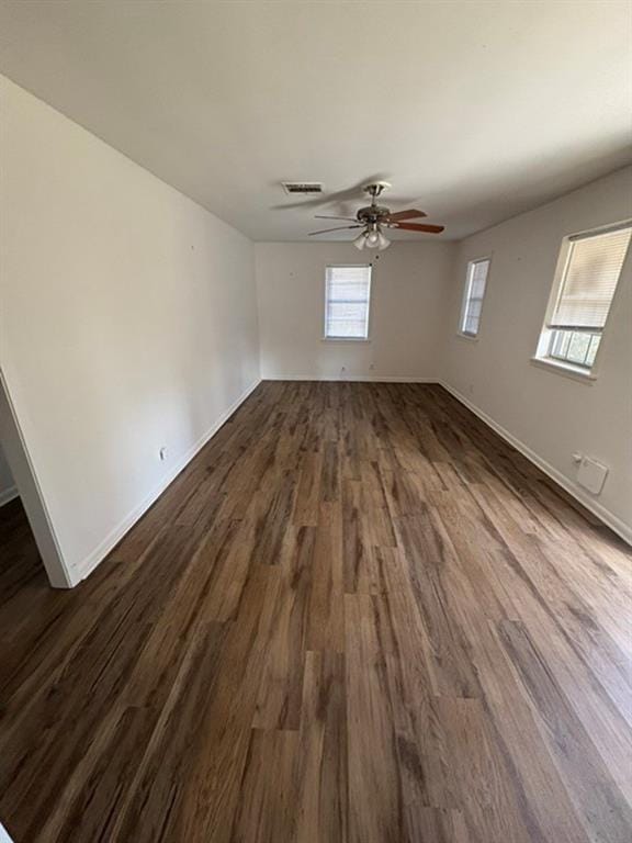 unfurnished room with ceiling fan and dark wood-type flooring