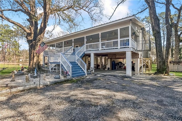 view of front of home featuring ceiling fan, a sunroom, and a carport