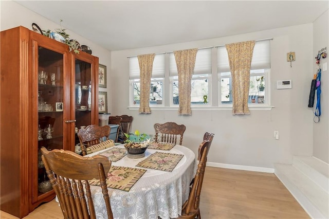 dining space featuring light wood-type flooring and a healthy amount of sunlight