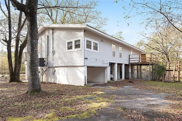 back of house featuring central AC and a wooden deck