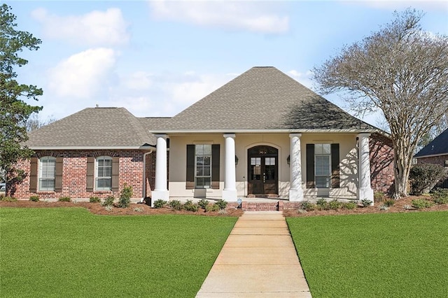 view of front of house with a shingled roof, covered porch, french doors, a front lawn, and brick siding