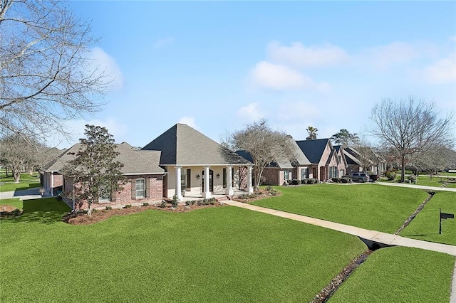 view of front of house with a porch, a front yard, brick siding, and a residential view