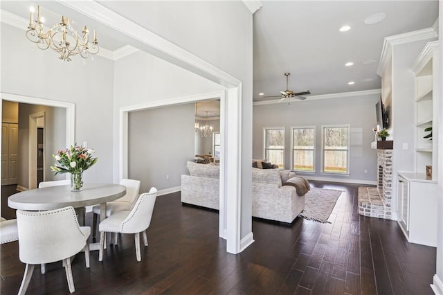 dining room featuring a towering ceiling, crown molding, dark hardwood / wood-style floors, and ceiling fan with notable chandelier