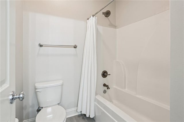 bathroom with hardwood / wood-style floors, toilet, and shower / tub combo