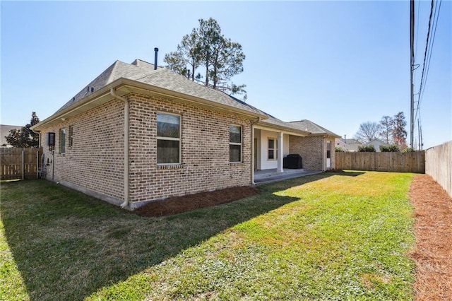 rear view of house featuring a yard and a patio area