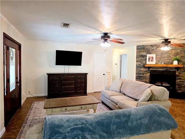 living room with crown molding, ceiling fan, and a fireplace