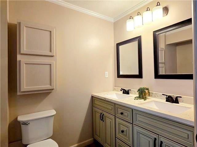 bathroom with vanity, crown molding, and toilet