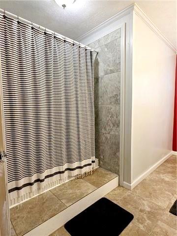 bathroom featuring ornamental molding and curtained shower