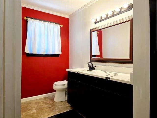 bathroom with vanity, crown molding, and toilet