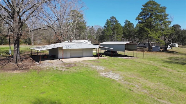 view of yard with a carport, an outdoor structure, and a garage