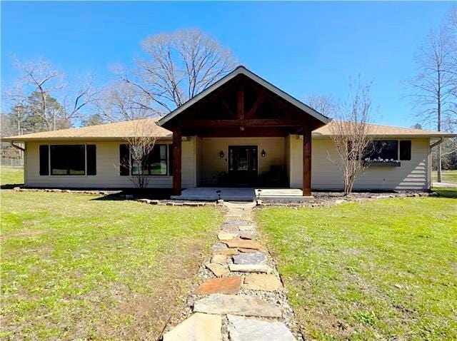 single story home with a front yard and a patio area