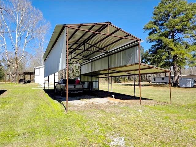 view of vehicle parking with a yard and a carport