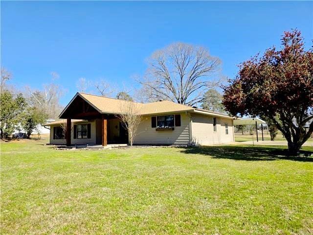 rear view of property featuring a lawn