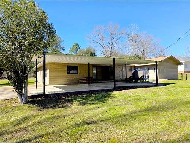 back of house featuring a yard and a carport