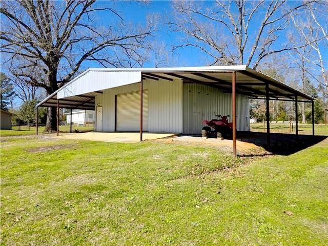 view of home's exterior featuring a garage, an outbuilding, and a yard