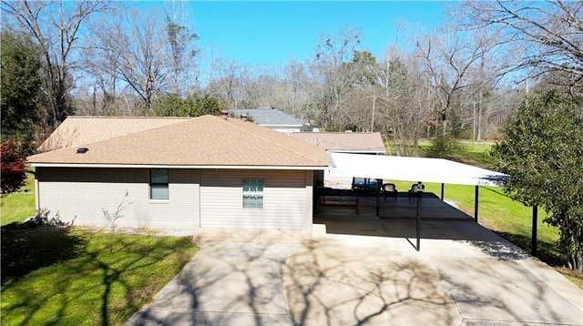 exterior space with a lawn and a carport