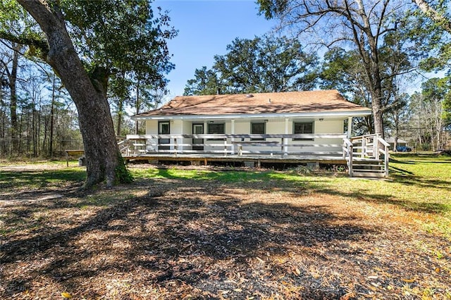 rear view of property with a deck and a lawn