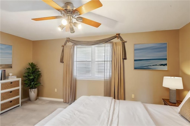 carpeted bedroom with ceiling fan and baseboards