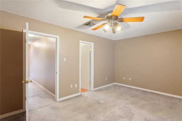 unfurnished bedroom with visible vents, a ceiling fan, a textured ceiling, carpet floors, and baseboards