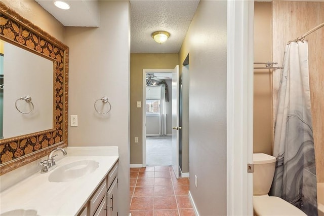 bathroom with vanity, baseboards, tile patterned flooring, a textured ceiling, and toilet