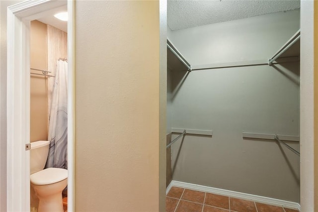 spacious closet with dark tile patterned floors