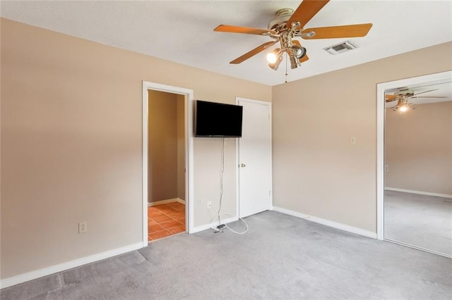 unfurnished bedroom with carpet flooring, baseboards, visible vents, and ceiling fan