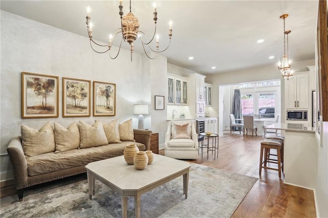 living room with dark wood-type flooring and an inviting chandelier