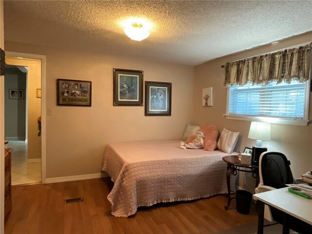 57428 Mainegra Rd, Slidell, LA 70460 - bedroom featuring baseboards, a textured ceiling, and wood finished floors