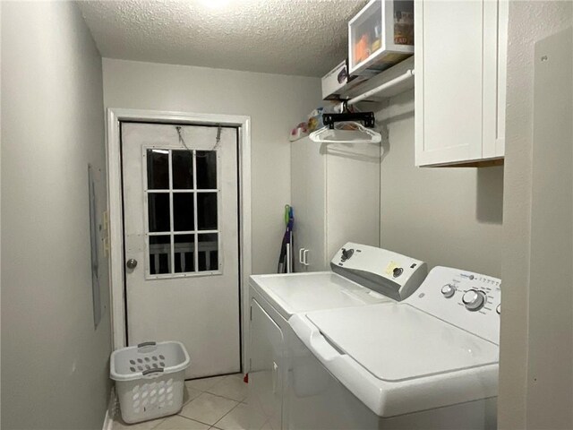 57428 Mainegra Rd, Slidell, LA 70460 - laundry area with light tile patterned floors, a textured ceiling, cabinet space, and washer and dryer