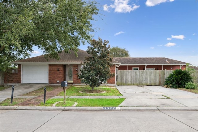 ranch-style home with an attached garage, fence, concrete driveway, and brick siding