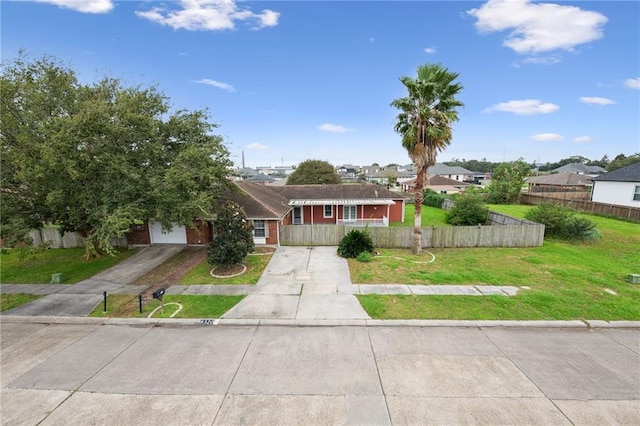 view of front of home with driveway, a fenced front yard, and a front yard