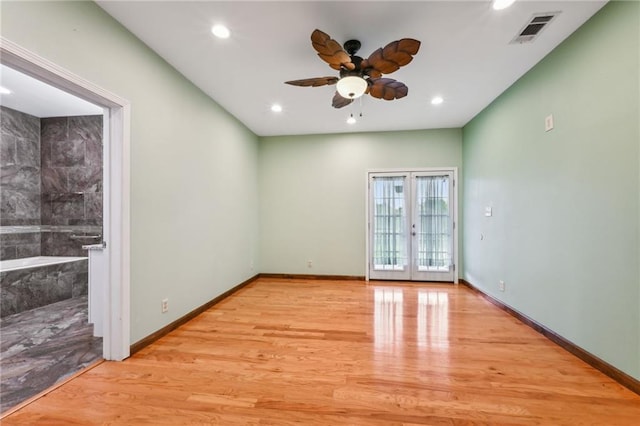 spare room featuring baseboards, visible vents, a ceiling fan, french doors, and light wood-type flooring