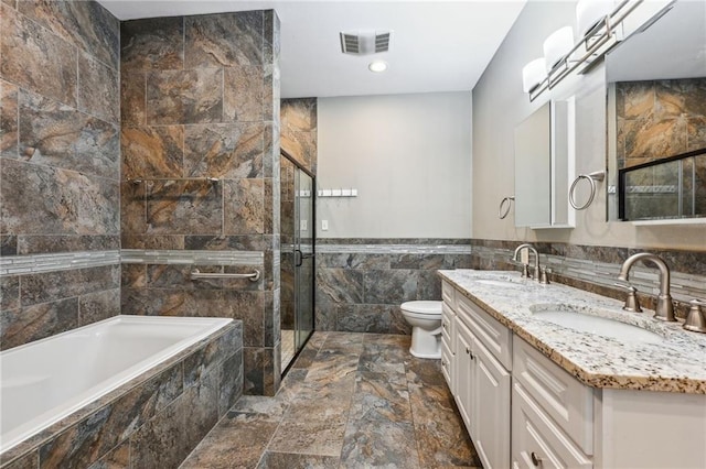 bathroom with toilet, a sink, visible vents, and tile walls