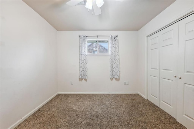 unfurnished bedroom with carpet, baseboards, ceiling fan, and a closet