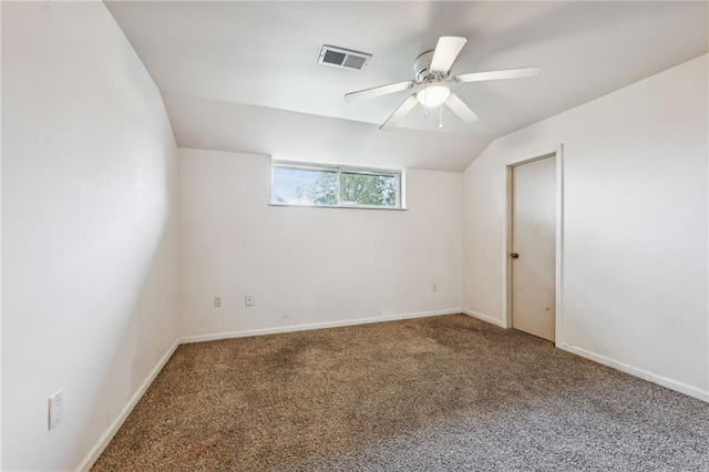 unfurnished room with visible vents, baseboards, ceiling fan, carpet, and vaulted ceiling