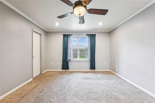 spare room with carpet floors, baseboards, and crown molding