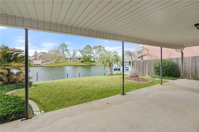 view of patio with a water view and fence