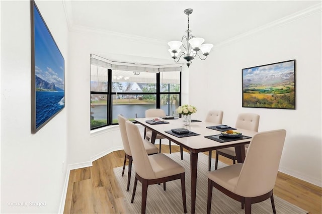 dining room with crown molding, light wood-style floors, baseboards, and a chandelier