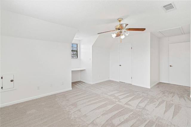 additional living space featuring carpet, visible vents, baseboards, attic access, and a textured ceiling